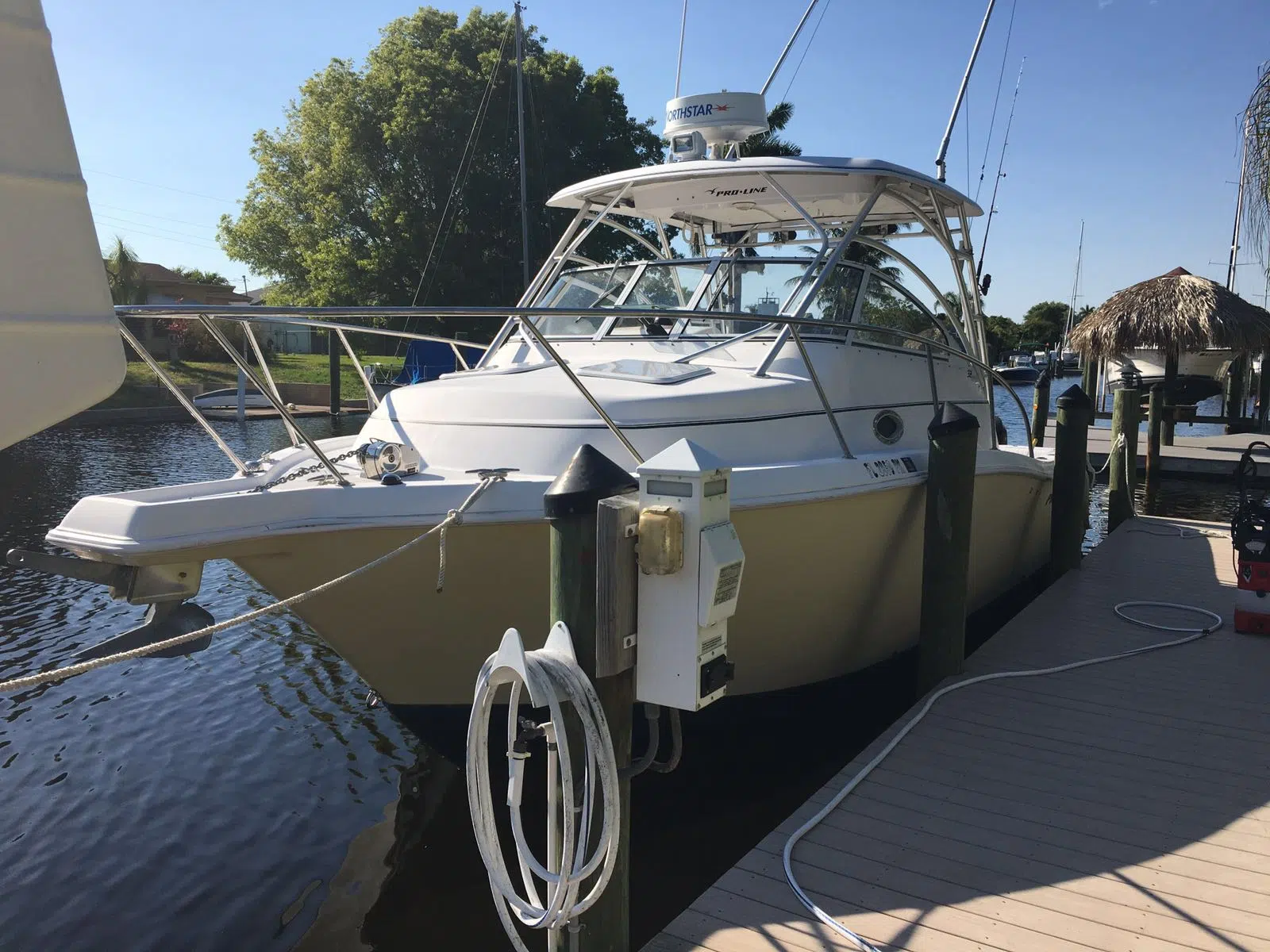 White walkaround boat docked beside a waterfront dock — JD Marine Service in Cape Coral